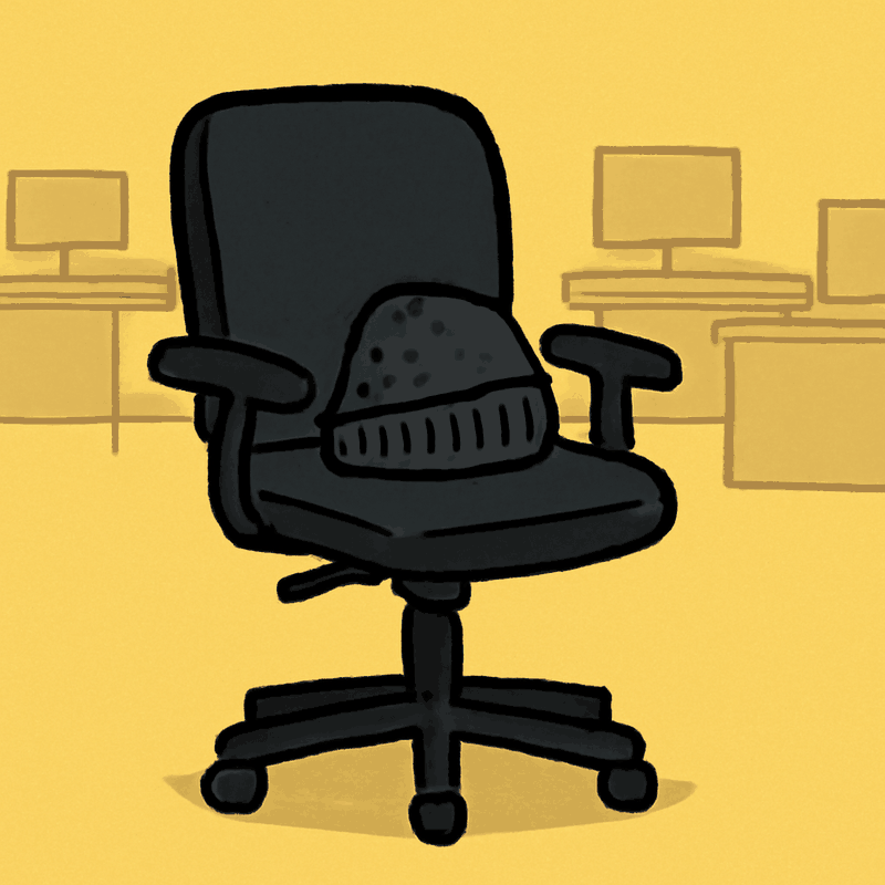 An empty office chair with a crumpled charcoal beanie left on the seat, fur stuck to the fabric, no one in it